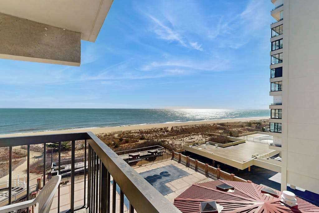Un balcon avec vue sur la plage et l’océan.