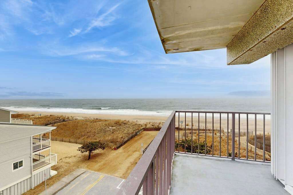 Un balcón con vista a la playa y al océano.