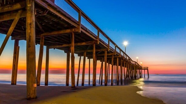 A wooden pier extending into the water with a clear sky above. - Bahia Vista II 304 (Ocean City)