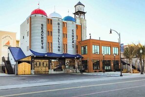 A building with large cylindrical structures labeled 'SECRETS' and 'DISTILLING COMPANY' on the side. - Bahia Vista II 304 (Ocean City)