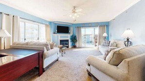 A living room with a fireplace, two sofas, a coffee table, and a TV. - Bahia Vista II 304 (Ocean City)
