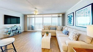 A modern living room with a sofa, coffee table, and TV. - Fountainhead Towers 1310 (Ocean City)
