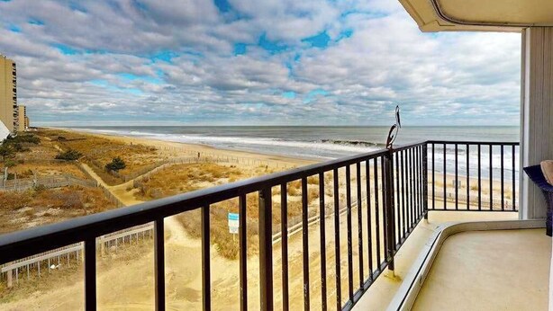 Un balcon avec vue sur la plage et l’océan.