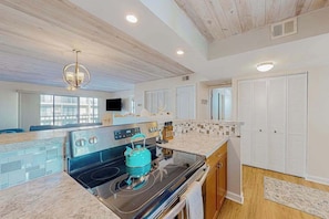 A modern kitchen with a built-in oven, a teal kettle, and a wooden ceiling. - Wight Bay South 360 (Ocean City)