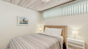Ein Schlafzimmer mit einem Bett, Nachttischen und einem Bild an der Wand.