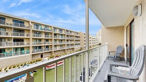 Un hotel de varios pisos con balcones, piscina y vista al río.