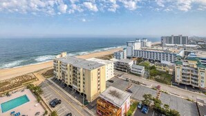 Ein Hotel an der Küste mit mehreren Gebäuden, einem Parkplatz und Blick auf den Strand.