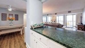 Cocina amplia con una isla grande, piso de madera y vista al área de estar.