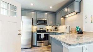 A modern kitchen with grey cabinets, stainless steel appliances, and a marble countertop. - La Vista Bay Complex -A,B,C,D (Ocean City)