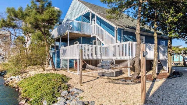 A multi-story house with a balcony, a staircase, and a dock extending into a body of water. - La Vista Bay Complex -A,B,C,D (Ocean City)