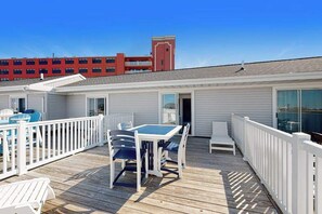 A deck with outdoor seating, a table, and chairs. - Beachwalk 23 (Ocean City)