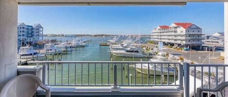 A balcony with a view of a marina, boats, and buildings.