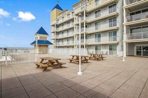 A multi-story hotel with balconies, outdoor seating, and a small tower-like structure. - Belmont Towers 801 (Ocean City)
