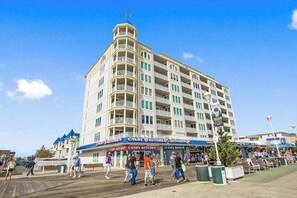 A multi-story hotel with balconies, a boardwalk in front, and a candy store. - Belmont Towers 801 (Ocean City)