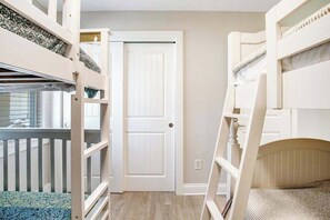 A room with bunk beds, a door, and a window. - Canalfront House w/ Private Deck, Central AC, Free WiFi, Bay Views, Washer/Dryer (Ocean City)