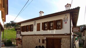 A traditional building with a stone facade, wooden shutters, and a sign indicating it is a restaurant.