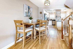 Ein Essbereich mit Holztisch und Stühlen, einem Blumentopf und einem Bild an der Wand.