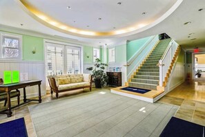 Ein großzügiger Wohnbereich mit Treppe, einer Couch und einem Esstisch.