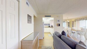 A hallway leading to a dining area with a sofa and a wicker basket. - Thunder Island 34B Bay views at Convention Center (Ocean City)