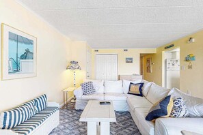 Een woonkamer met een bank, een bijzettafeltje en een lamp.