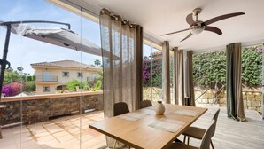 A dining area with a table, chairs, and a ceiling fan.
