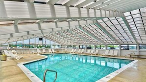 Una piscina interior con vista despejada al cielo a través de la estructura del techo.