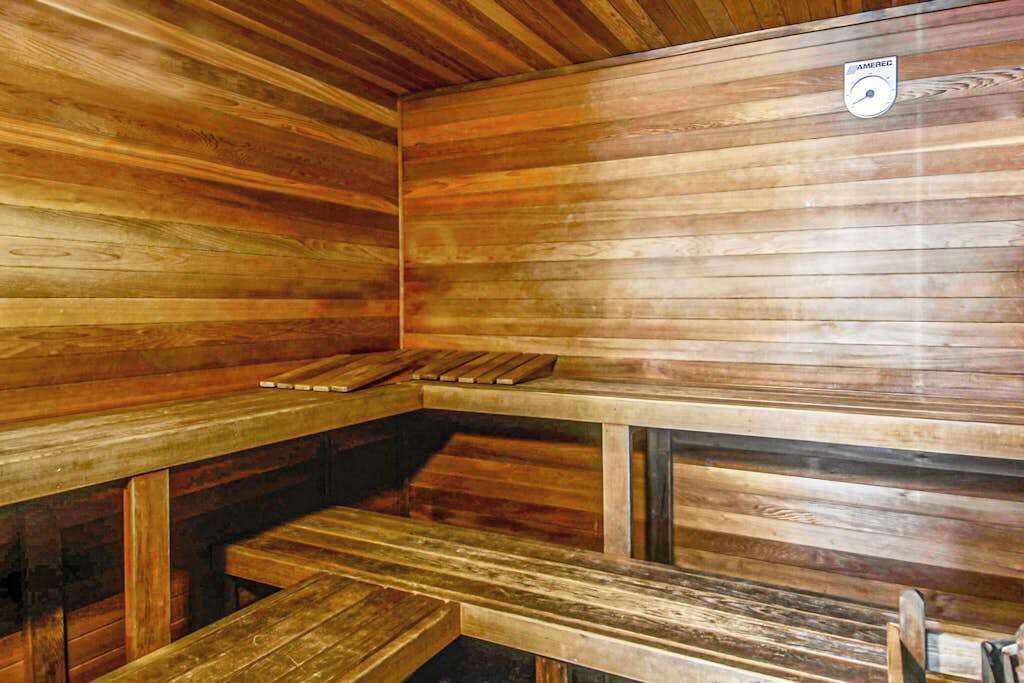 Sauna, jossa on puiset lauteet ja selkeästi näkyvä lämpömittari.