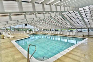 Ein Hallenbad mit hoher Decke, klaren Glasscheiben und sonnigen Liegebereichen.