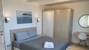 A modern bedroom with a bed, a wardrobe, a desk with a chair, and a wall-mounted mirror. - Fouka North Coast SA-4B-203 (Marsa Matrouh)