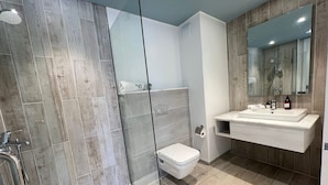 A modern bathroom with a glass shower enclosure, a white toilet, and a vanity with a mirror. - Fouka North Coast SA-4B-203 (Marsa Matrouh)