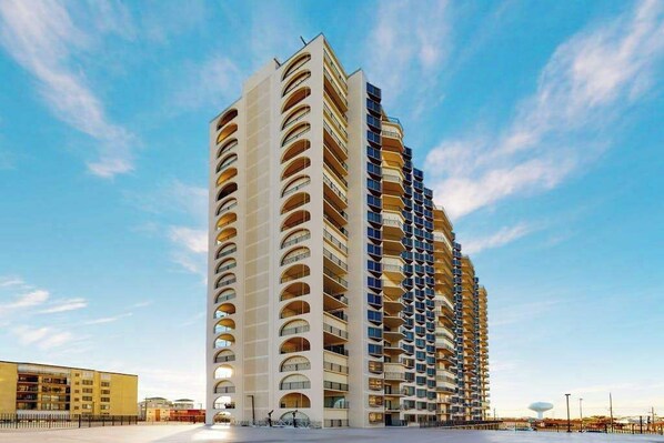 Um edifício moderno e imponente com várias varandas e um céu limpo.