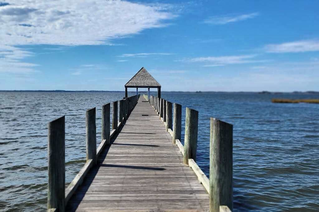 Un muelle de madera que se adentra en el agua, con un pabellón al final.