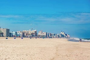 Een strand met gebouwen op de achtergrond.