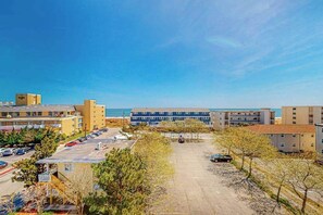 A coastal hotel with multiple buildings, a parking lot, and a clear view of the ocean. - Key Largo Penthouse w/ Ocean View, W/D, WiFi, AC - Half a Block to the Beach (Ocean City)