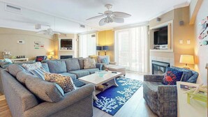 A living room with a sofa set, a coffee table, a fireplace, and a ceiling fan. - Adagio 407 (Ocean City)