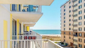 A multi-story hotel with balconies overlooking a beach. - Adagio 407 (Ocean City)