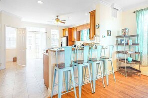 A kitchen with a dining area, wooden cabinets, and a ceiling fan. - Saint Louis Ave townhouse central AC & private washer/dryer - near the ocean (Ocean City)