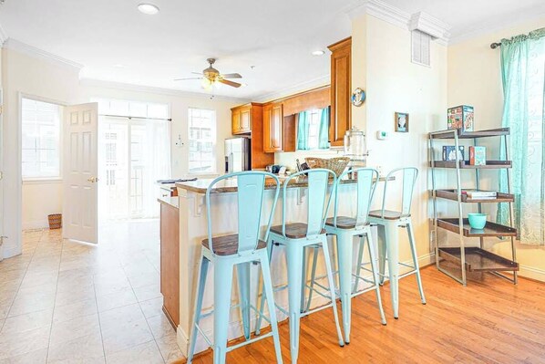 A kitchen with a dining area, wooden cabinets, and a ceiling fan.