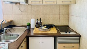 A compact kitchen with a microwave, sink, and a small refrigerator. - Apartamento Faro 77 by At Home Costa del Sol (Torrox)