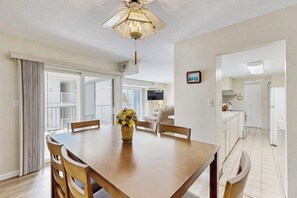 A dining area with a table, chairs, and a ceiling fan. - Fourth-Floor Condo near the Beach w/Private Balcony, Ocean View, A/C, Free WiFi (Ocean City)