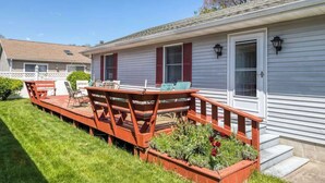 Ein Wohnhaus mit Terrasse, Gartenmöbeln und einem Garten.