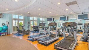 Un gimnasio con cintas de correr, pelotas de ejercicio y máquinas de pesas.