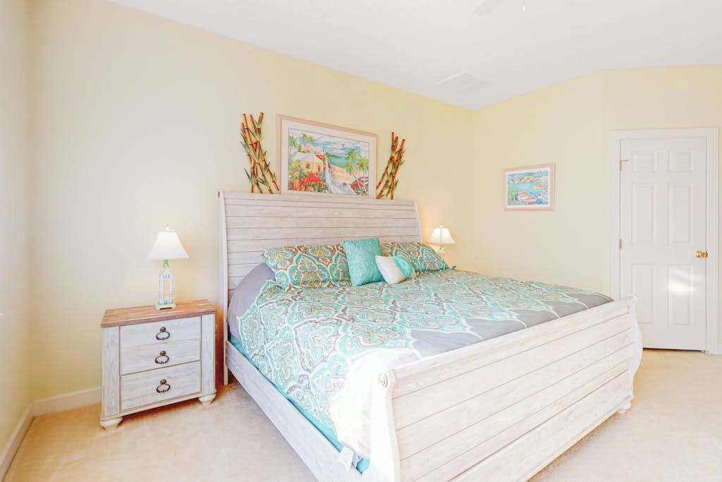 Un dormitorio con cama, mesitas de noche y decoración en la pared.