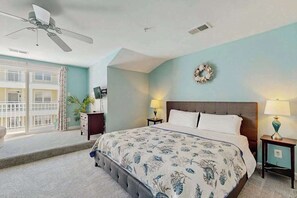 A bedroom with a bed, a ceiling fan, a wall-mounted wreath, and a balcony with curtains. - Spacious Townhome w/ Bay Views & WiFi - Walk to Resort Pools/Beaches (Ocean City)