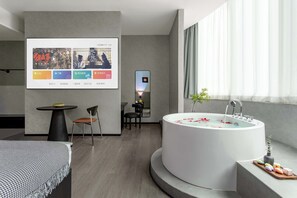 A modern bathroom with a freestanding bathtub, a small table with chairs, and a large window with curtains. - Banana FUN Hotel (Guangzhou Beijing Road Pedestrian Street Yuexiu Park) (Guangzhou)