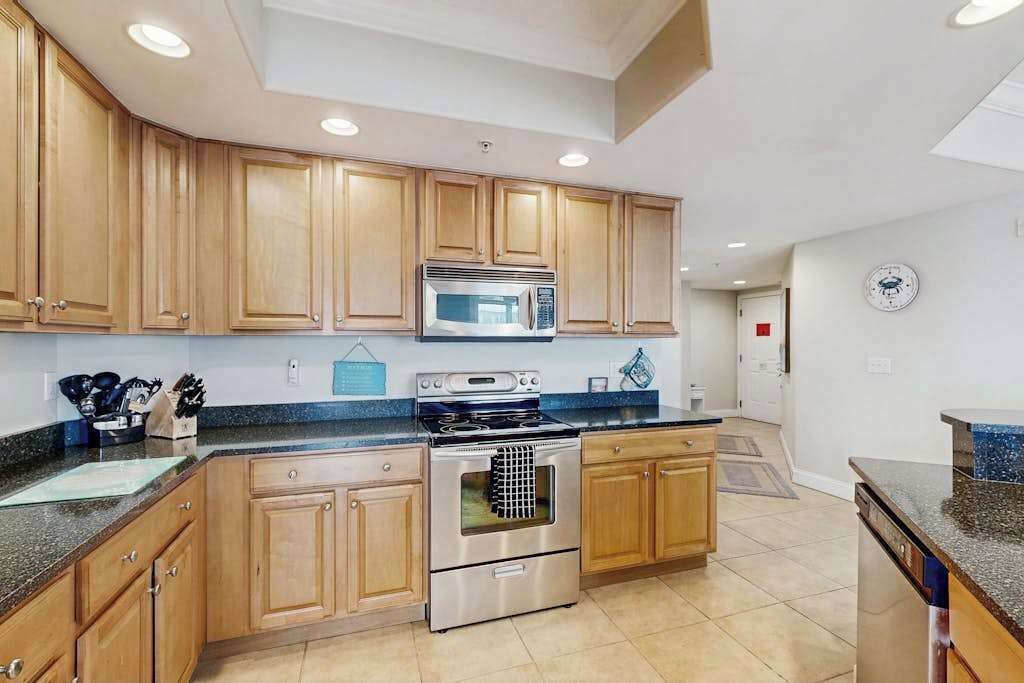 A kitchen with wooden cabinets, a stainless steel stove, and a microwave.