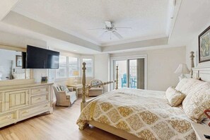 A bedroom with a bed, a dresser, a television, and a ceiling fan. - 4100 #201 (Ocean City)