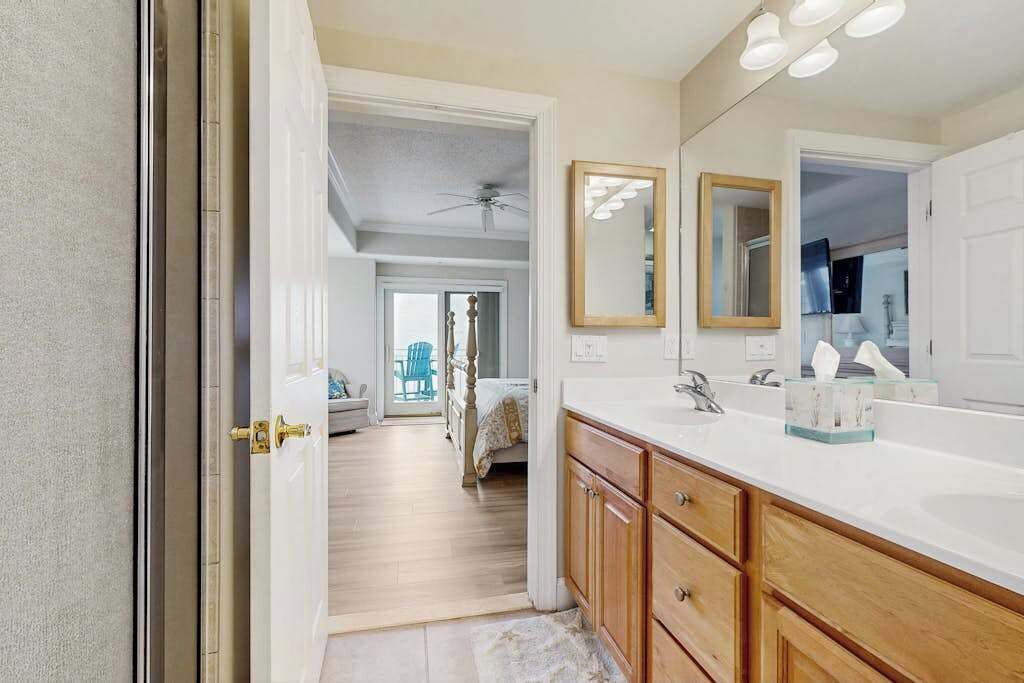 A bathroom with a double sink, wooden cabinets, and a large mirror.