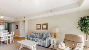 A living room with a sofa, a chair, a coffee table, and a lamp. - Midtown Condo with Balcony, Gas Fireplace, Washer/Dryer, WiFi & Shared Pool (Ocean City)