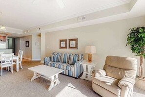 A living room with a sofa, a chair, a coffee table, and a lamp. - Midtown Condo with Balcony, Gas Fireplace, Washer/Dryer, WiFi & Shared Pool (Ocean City)